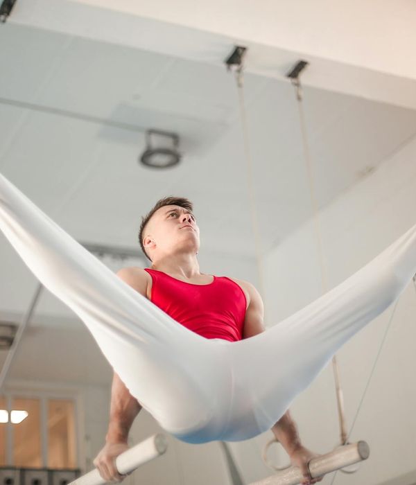 Man performing a controlled strength exercise in a bright space.
