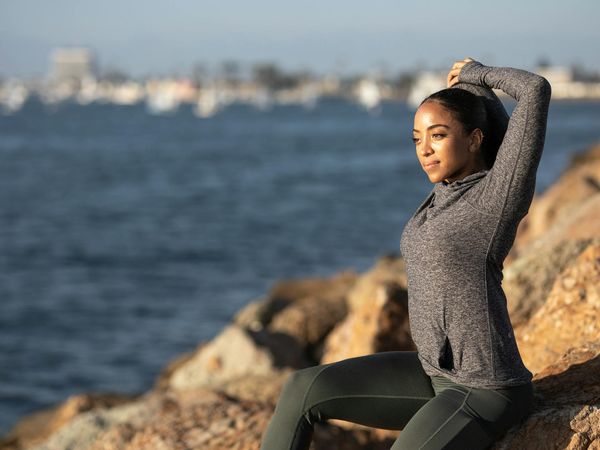 Silhouette of a person stretching at sunrise, suggesting overall wellness.
